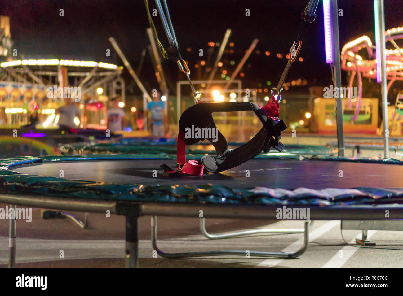 Trampoline Bungee dans un parc d'attractions de nuit Photo Stock - Alamy