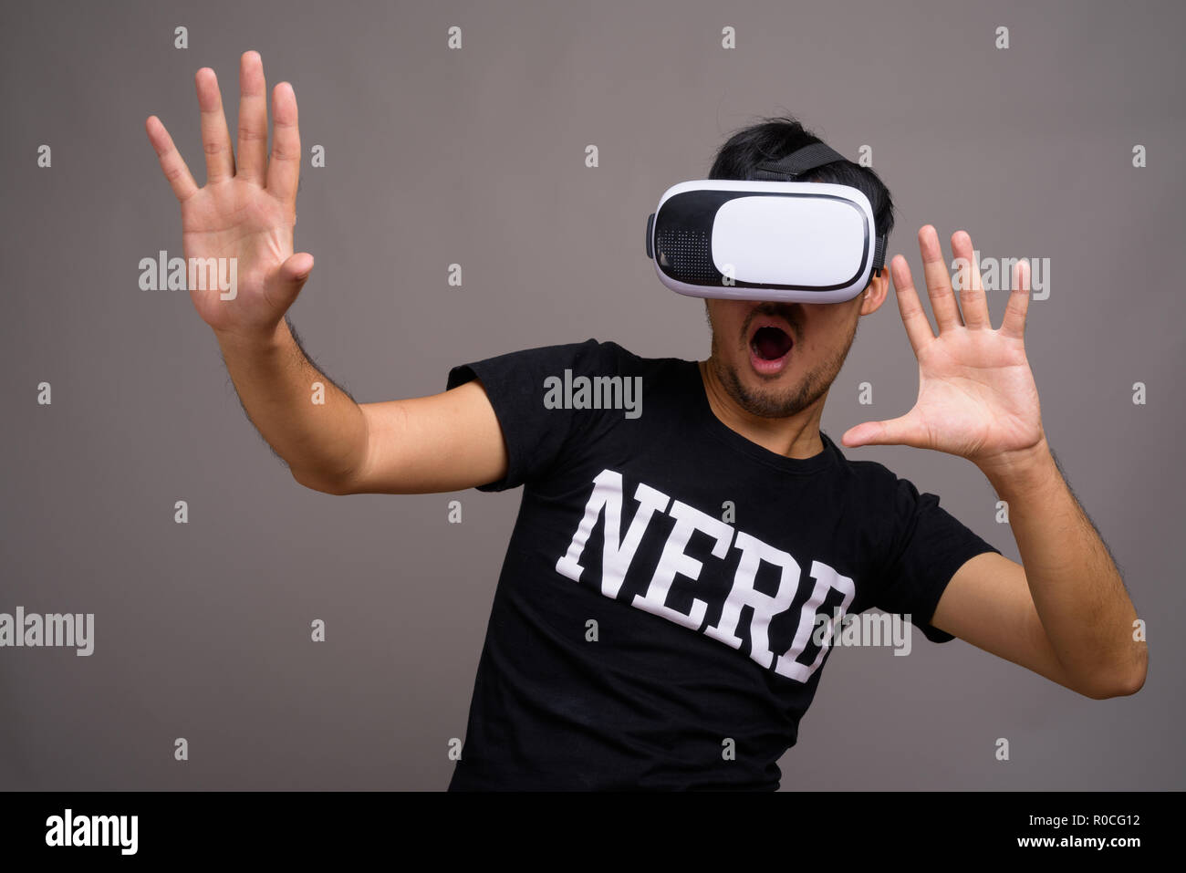 Young Asian nerd man à l'aide de casque de réalité virtuelle Banque D'Images