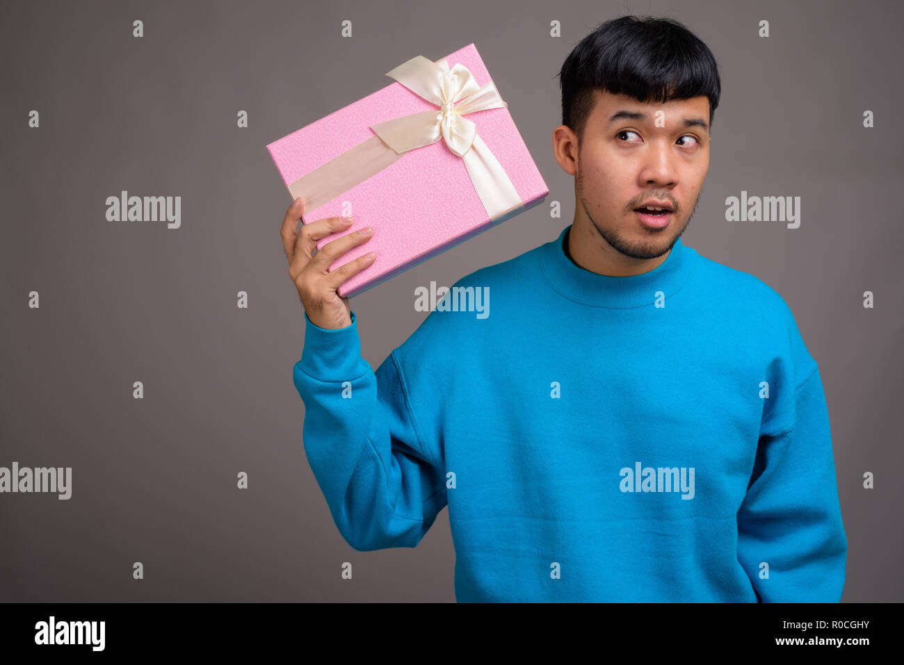 Portrait of young Asian man holding gift box Banque D'Images