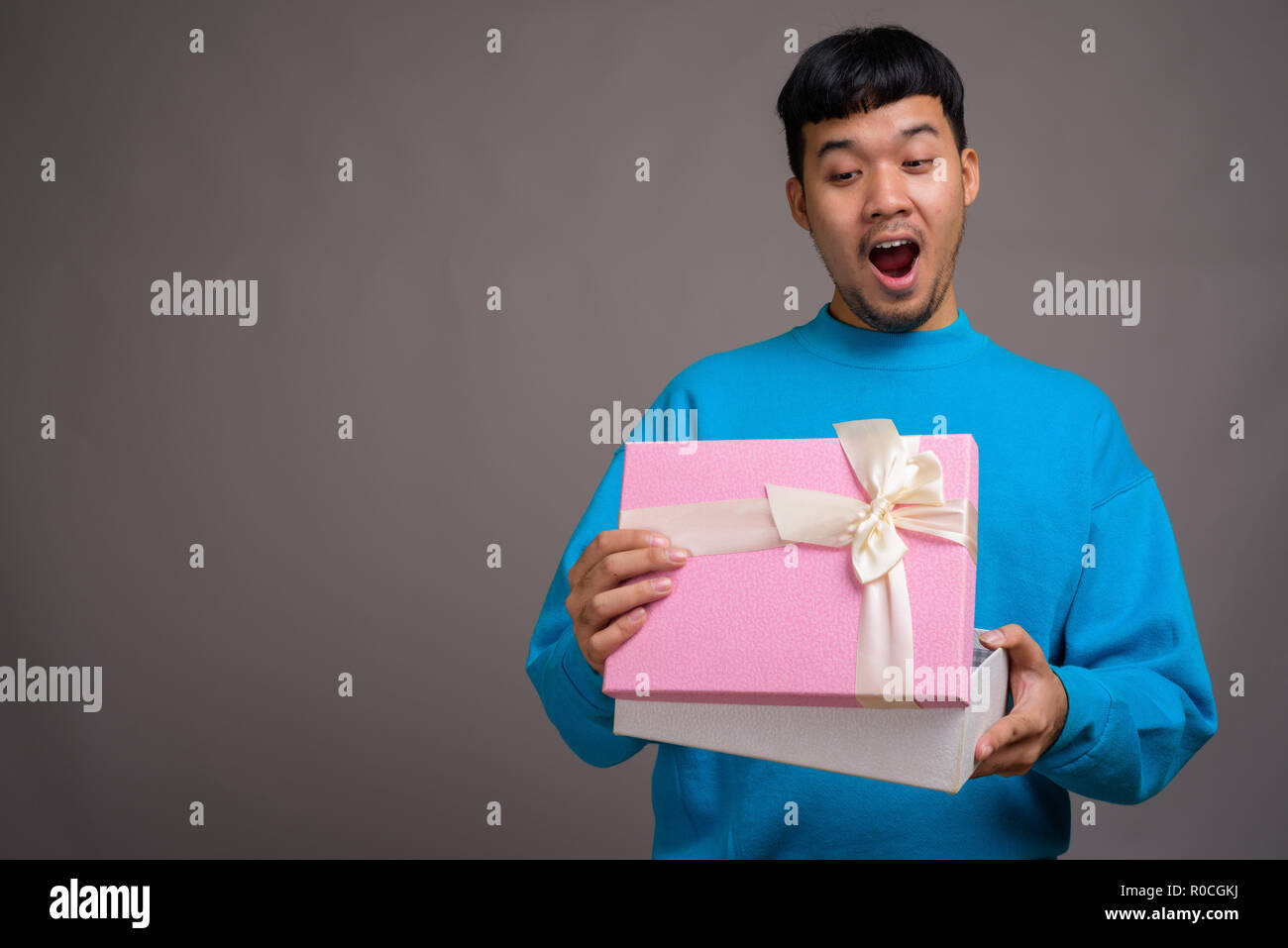 Portrait of young Asian man holding gift box Banque D'Images