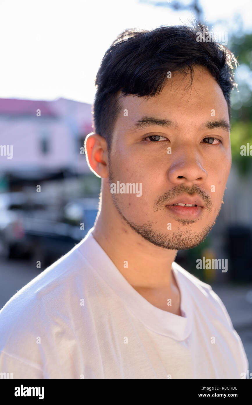 Jeune homme asiatique se détendre dans les rues à l'extérieur Banque D'Images