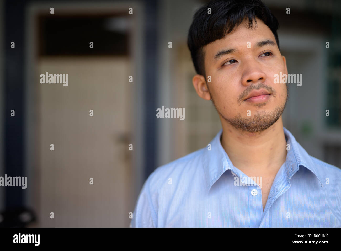 Young Asian businessman thinking à la maison à l'extérieur Banque D'Images