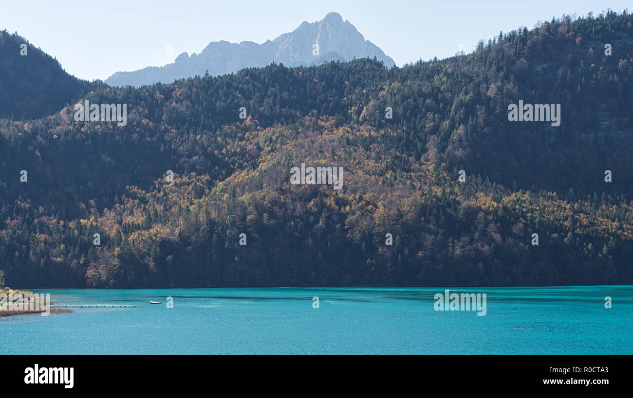 Vue sur le lac de couleur turquoise 'Alpsee' et l'Alpseebad depuis un sentier autour du lac en automne. Schwangau, Füssen, Bavière, Allemagne Banque D'Images