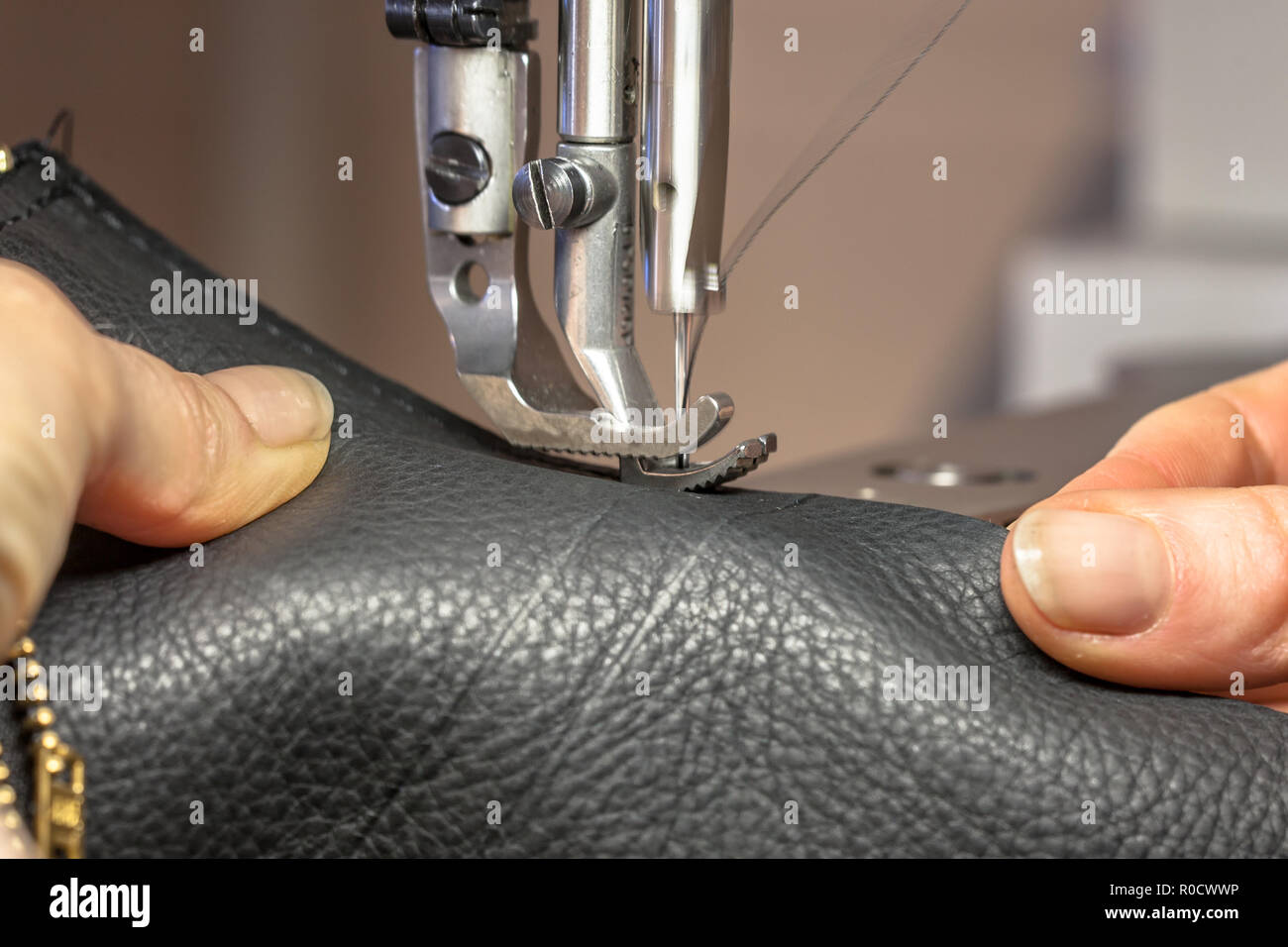 Mains travaillant sur une machine à coudre en cuir en action Banque D'Images
