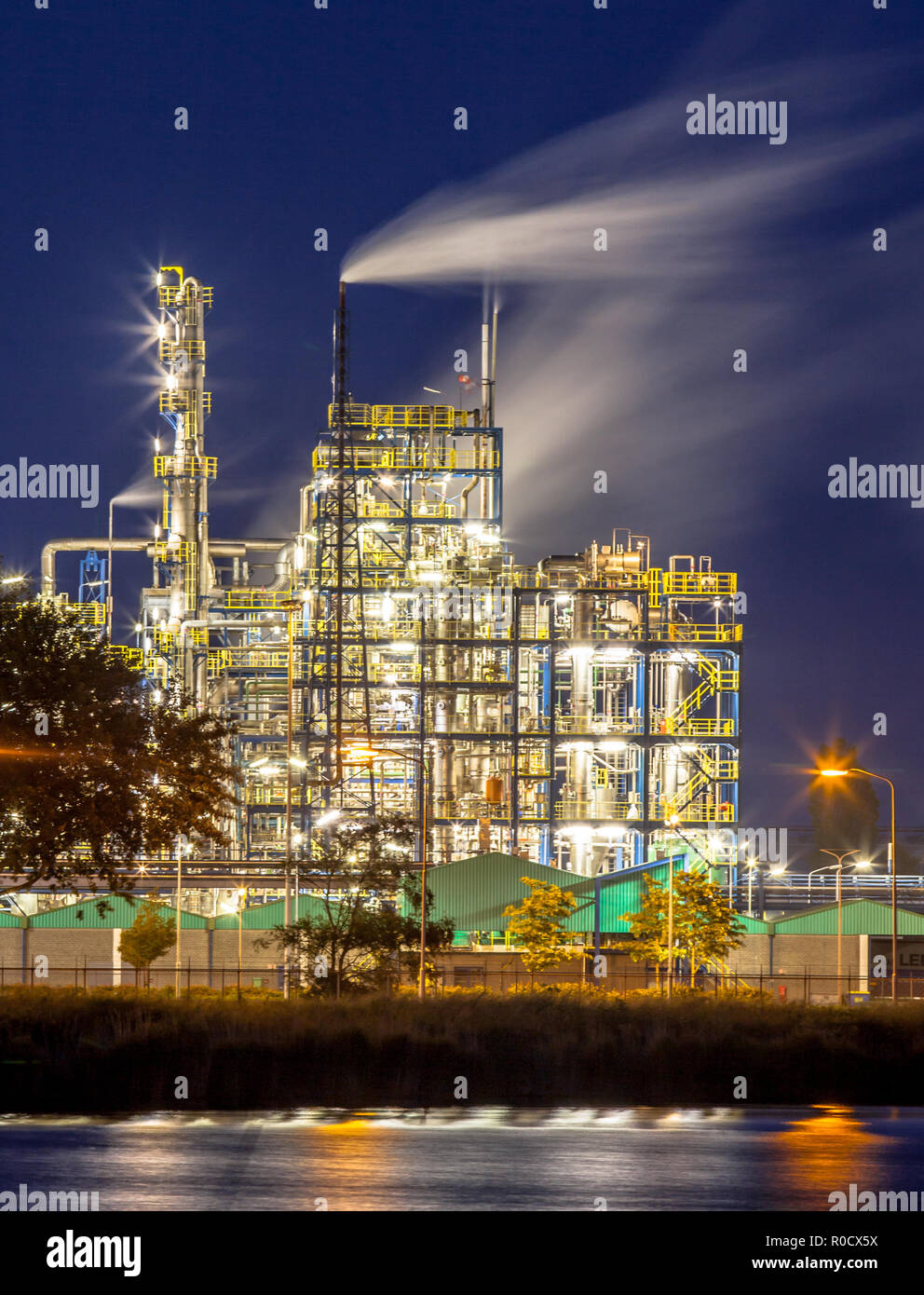 Scène de nuit de détail d'une installation industrielle chimique lourde avec mazework de tuyaux et de pipelines dans Twilight Banque D'Images