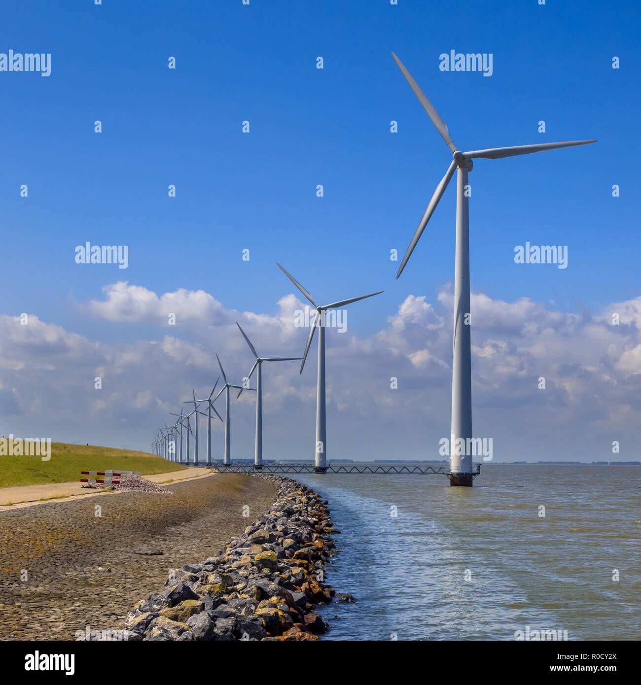 Longue rangée d'éoliennes offshore dans l'eau situé le long de la côte Banque D'Images Longue rangée d'éoliennes offshore dans l'eau situé le long de la côte Banque D'Images
