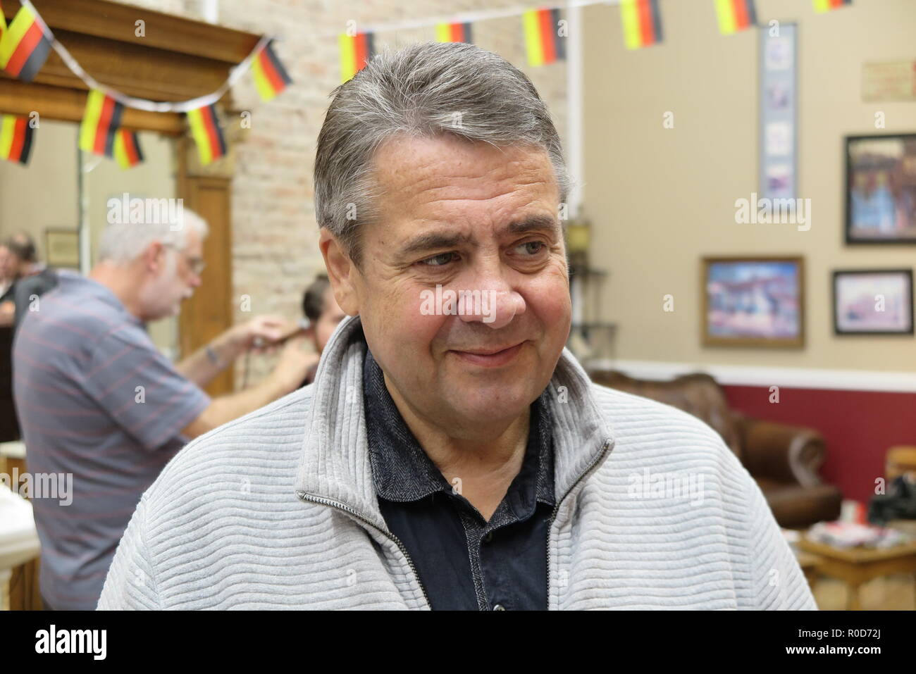 Martinsburg, USA. 06Th Nov, 2018. L'ancien ministre fédéral des affaires étrangères, Sigmar Gabriel (SPD) parle aux visiteurs dans 'oncle Joe's Barbershop'. En l'honneur de la visite de Gabriel, le propriétaire a raccroché les petits drapeaux allemands. Gabriel a visité l'état américain de la Virginie de l'Ouest, fief de nous Président Trump. Il voulait parler aux gens de comprendre pourquoi il y avait tant d'Atout il y a soutien. Il l'a fait en oncle Joe's Barbershop, entre autres. (Dpa ''Sigmar'' de l'Allemagne en Trump-Land - Gabriel' à partir de 04.11.2018) Crédit : Pouvez Saint Denis le ferment/dpa/Alamy Live News Banque D'Images