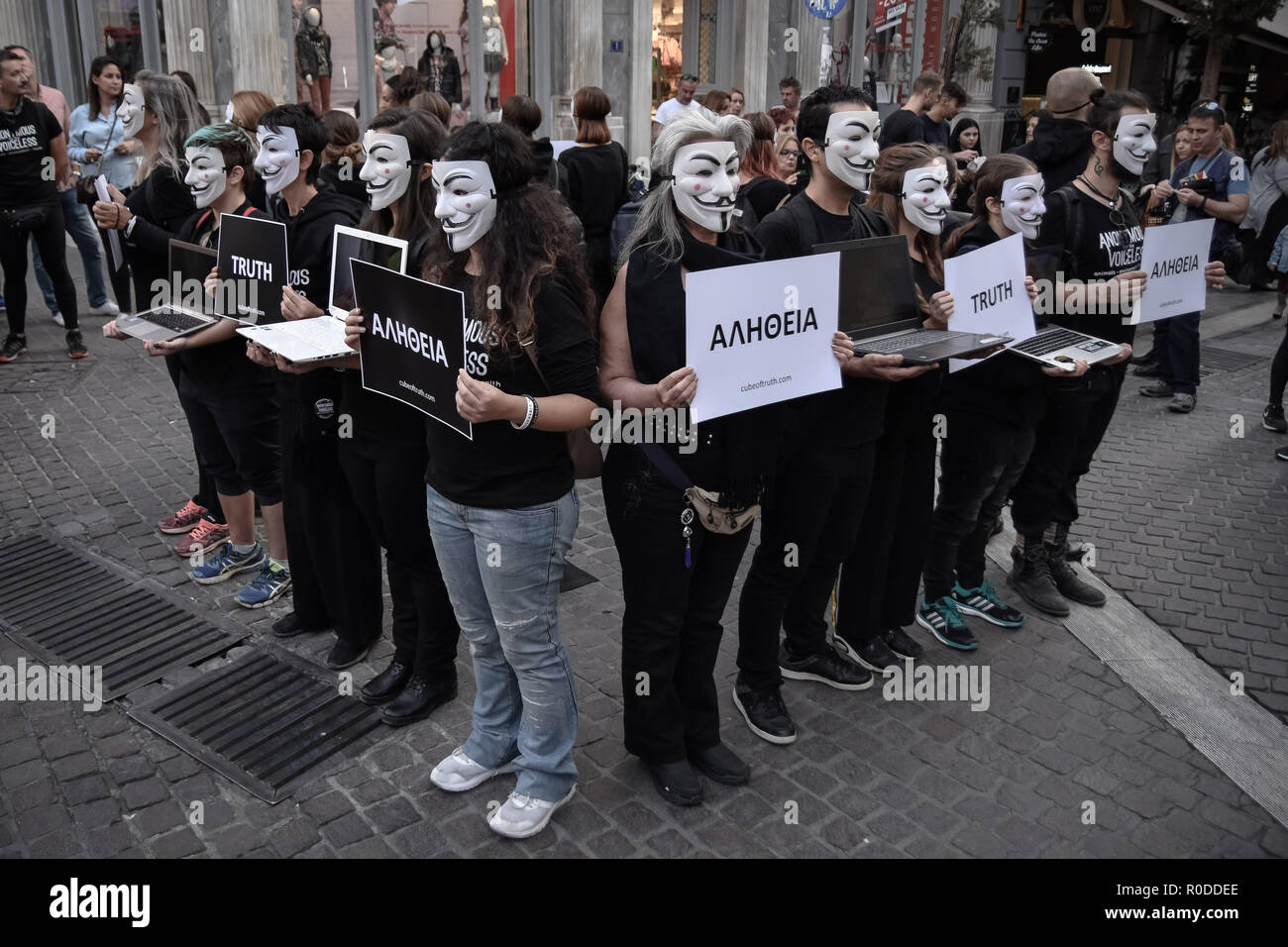 Les participants sont vus portant des masques anonymes tout en tenant des pancartes pendant la manifestation. Anonymous est un groupe d'activistes végétaliens portant des vêtements noirs en maintenant des ordinateurs portables et des pancartes comme ils manifester contre l'exploitation des animaux, le Cube de Vérité est un paisible démonstration statique s'apparente à un art de performance. Banque D'Images