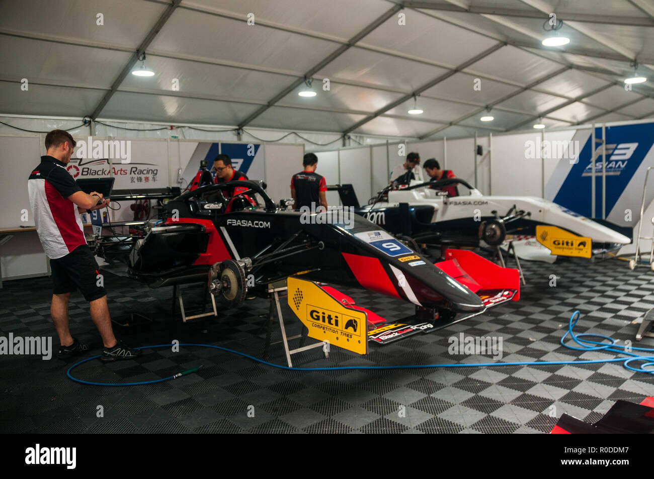 Arts noirs Racing Team F3 Asie les voitures de course en cours de maintenance dans les fosses de la Shanghai Circuit. Banque D'Images