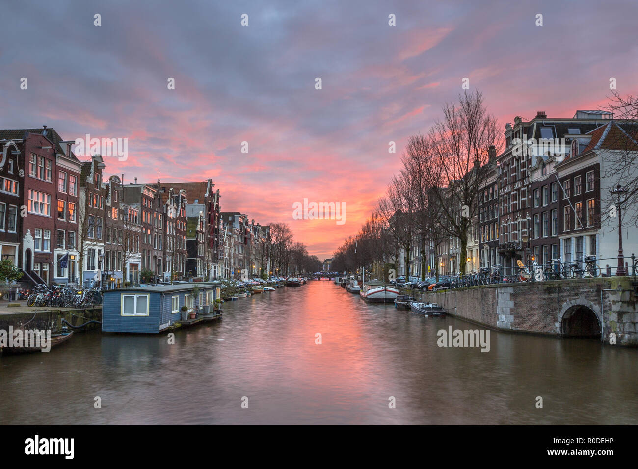 Plus de soleil colorés avec d'Herengracht canal traditionnelle et bateau maison maisons dans le site du patrimoine mondial de l'Unesco d'Amsterdam Banque D'Images