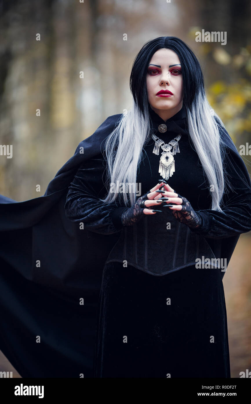 Photo de vampire femme en manteau noir sur fond flou Photo Stock - Alamy