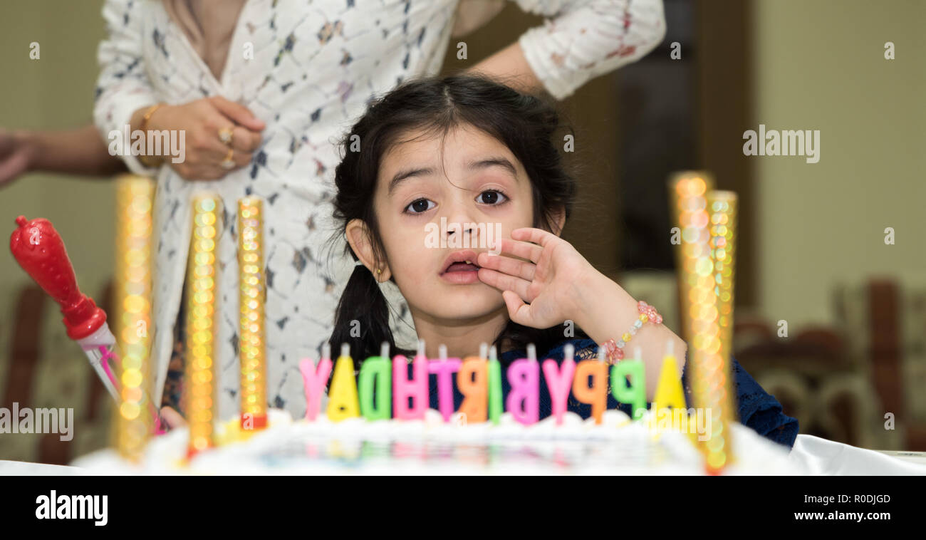 Une petite fille qui pose pour appareil photo de anniversaire celeberation Banque D'Images