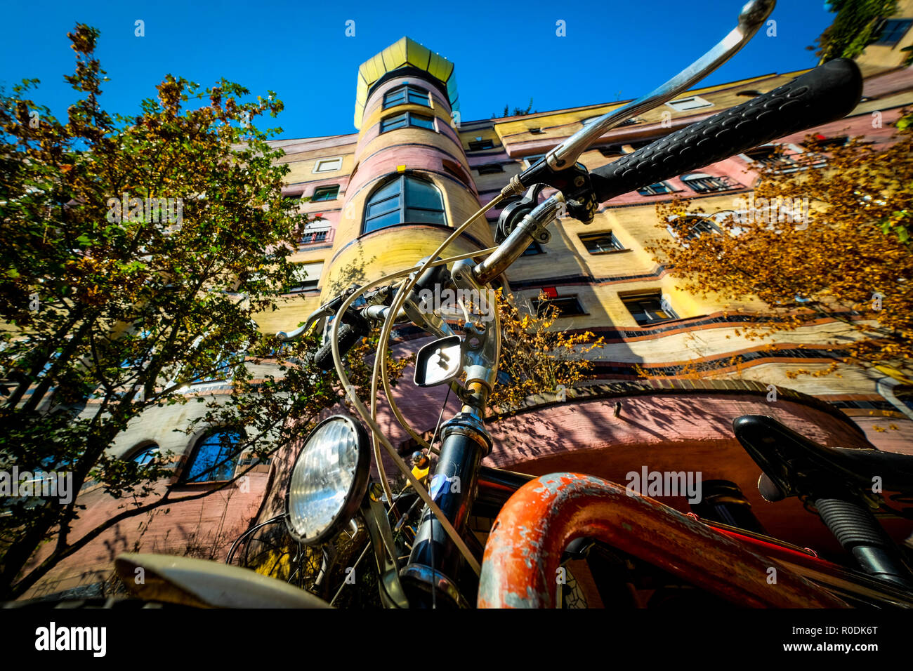 Vieille moto rouillée en face d'un bâtiment coloré prises à partir d'un point de vue très étroit Banque D'Images