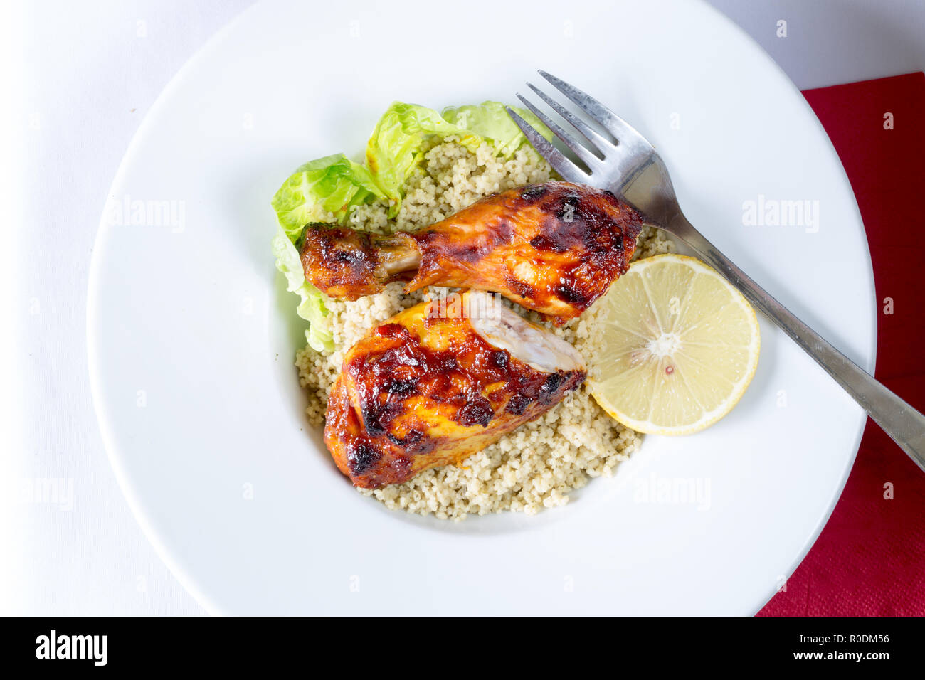 Jamaican Jerk Poulet BBQ style jambes avec citron et à la coriandre couscous Banque D'Images