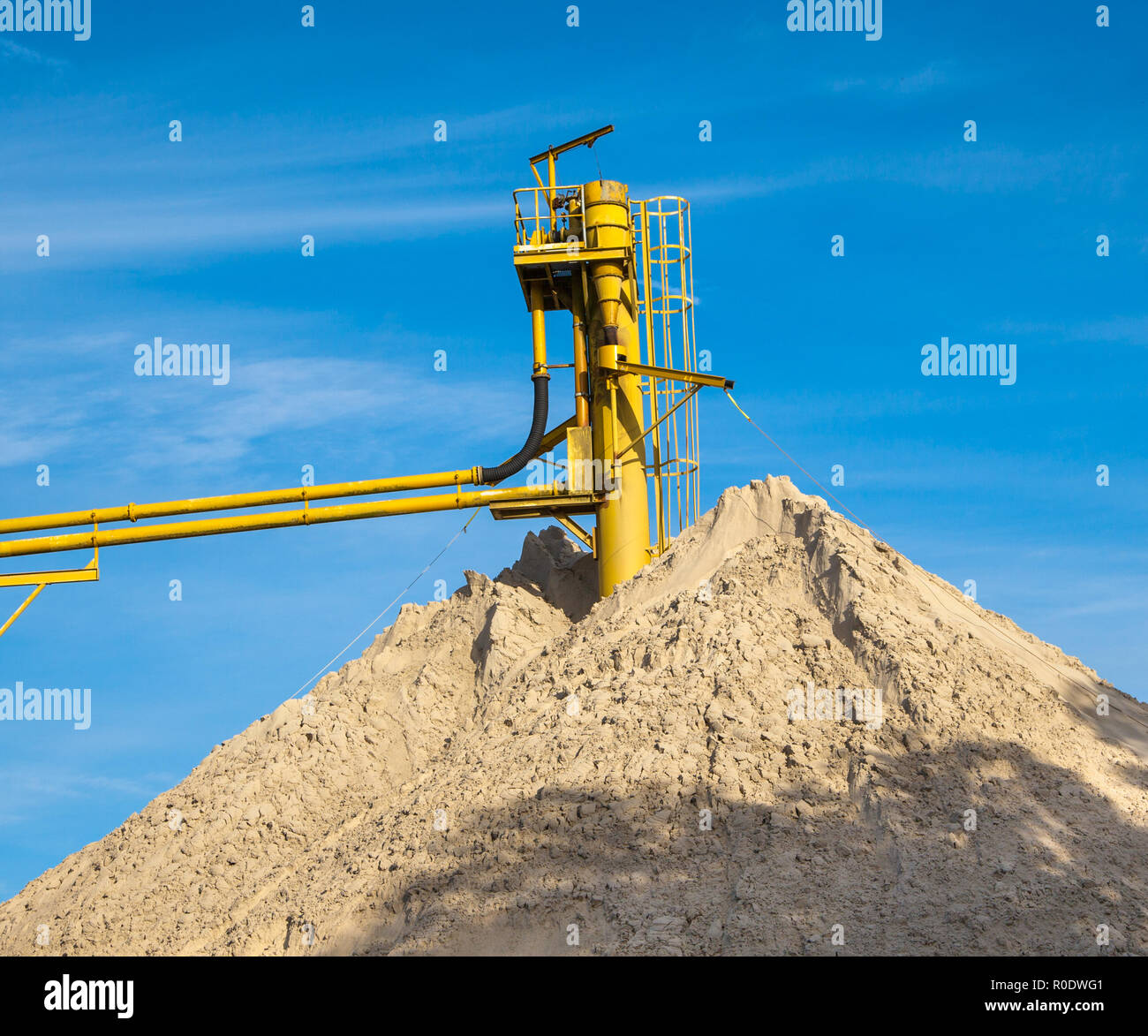 Convoyeur de la mine à une colline de sable avec ciel bleu Banque D'Images