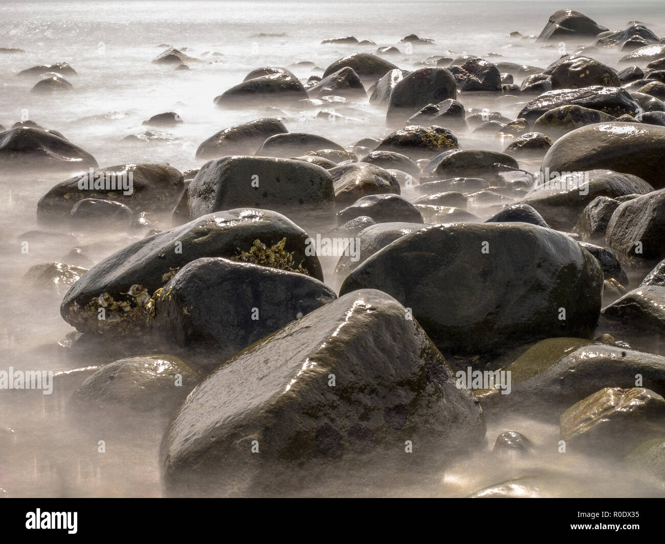 Une longue exposition libre de rochers dans la mer Banque D'Images Une longue exposition libre de rochers dans la mer Banque D'Images