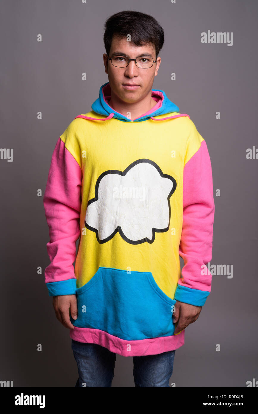 Young Asian man wearing colorful hoodie et lunettes contre g Banque D'Images