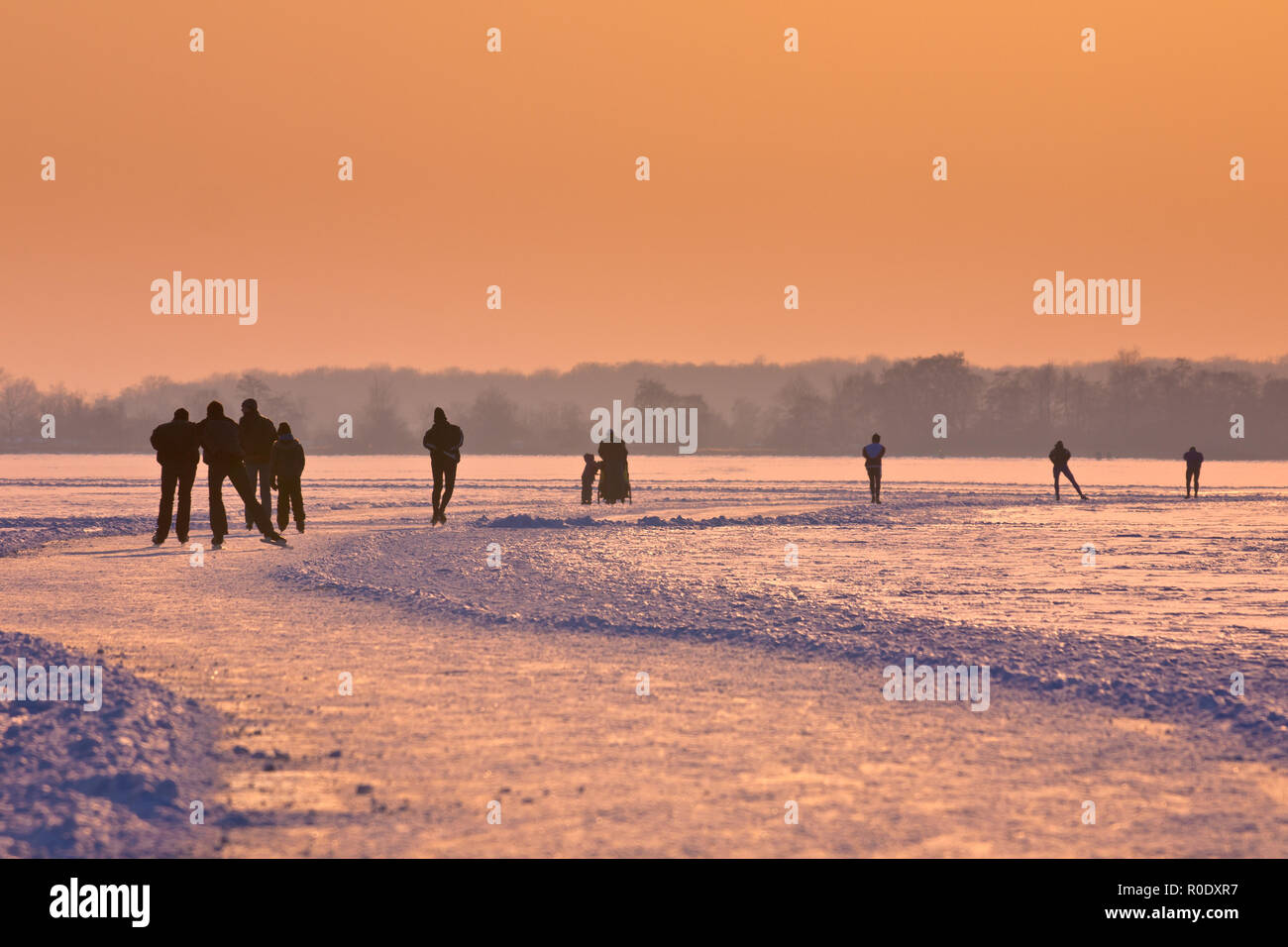 Patineurs sur un lac vu sur leur dos pendant les onze villes d' Banque D'Images