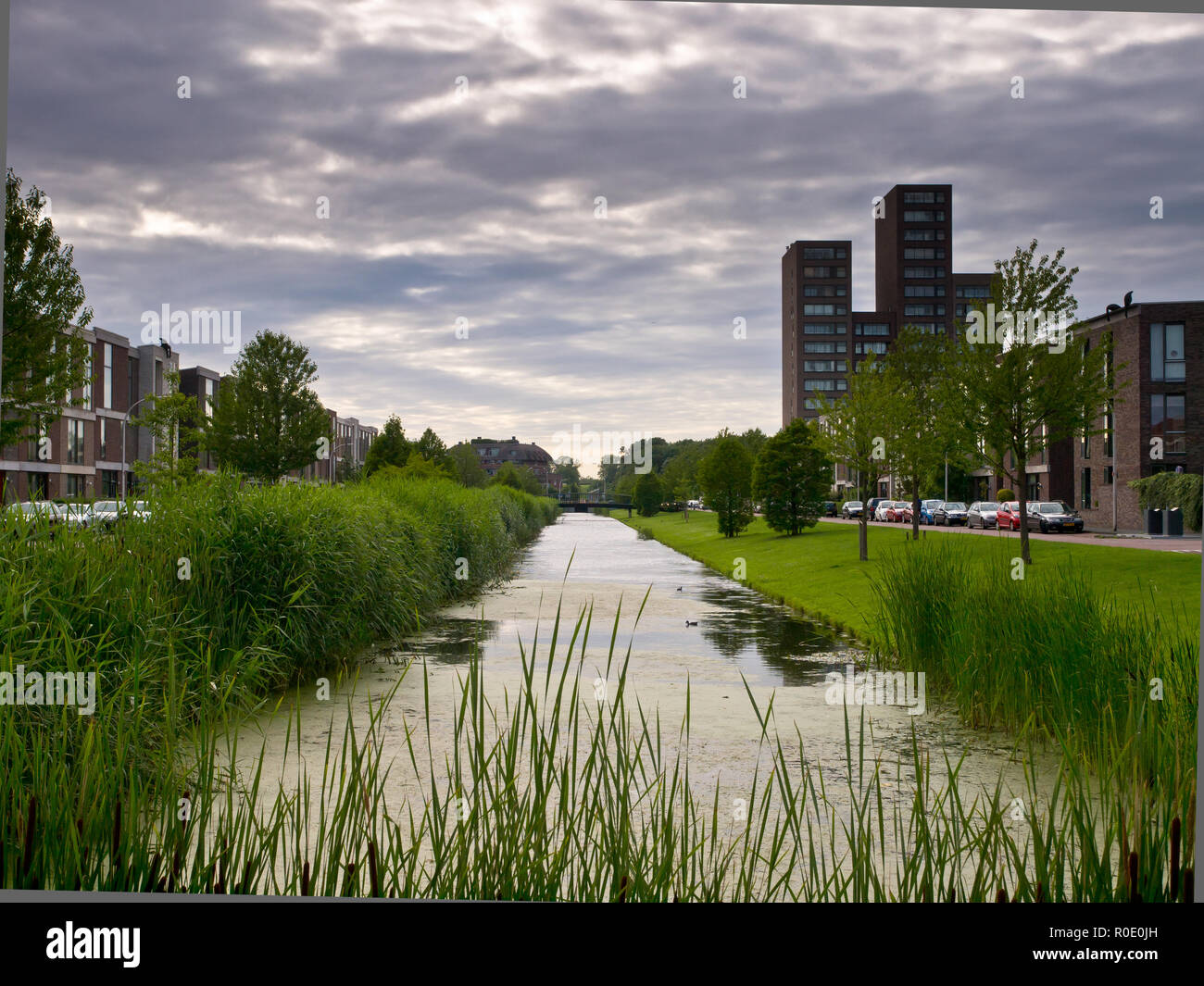 Canal dans un quartier résidentiel de banlieue néerlandais Banque D'Images
