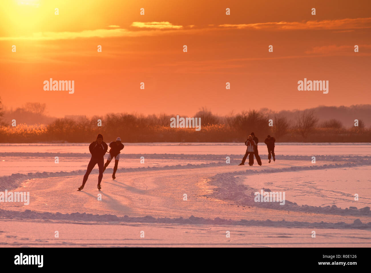 Les patineurs de vitesse néerlandais sont de retour éclairé par un soleil couchant Banque D'Images
