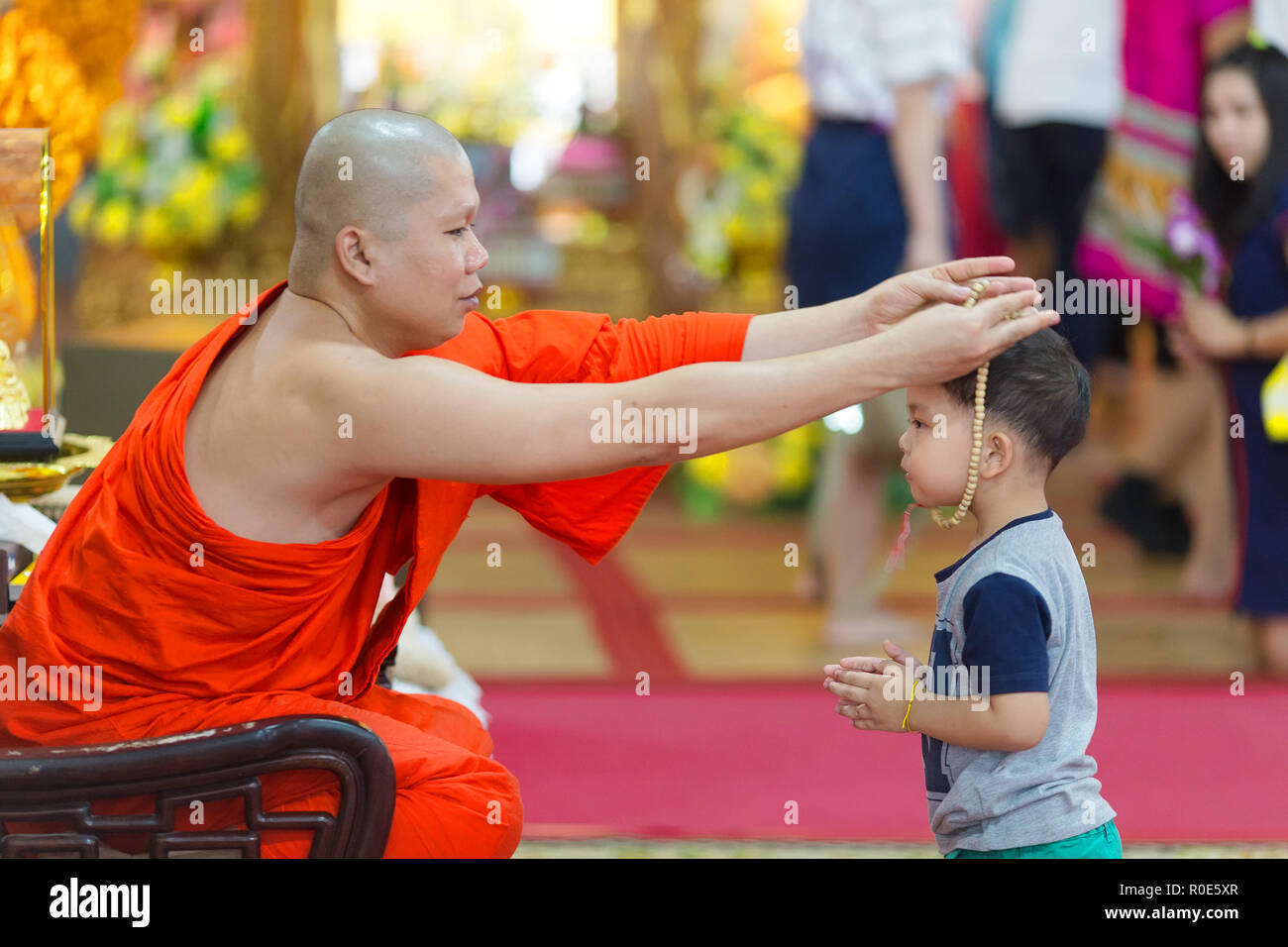SANGKHLABURI, Thaïlande, le 24 janvier 2016 : un moine bouddhiste est une bénédiction par l'insertion d'un petit garçon collier chapelet autour de son cou dans le Wat Wang W Banque D'Images
