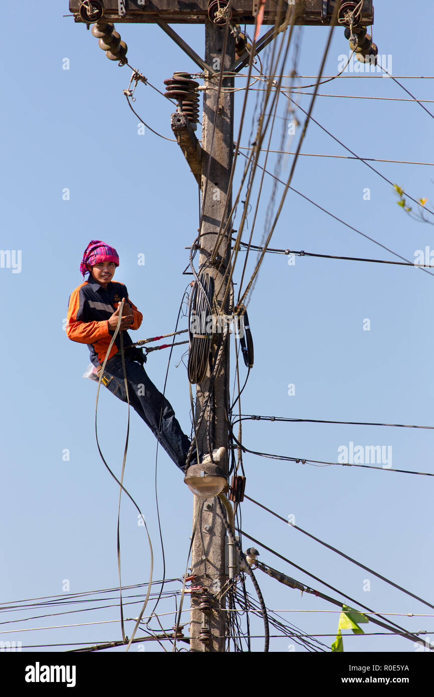 SAI YOK, Thaïlande, le 22 janvier 2016 : Un technicien est la réparation ou vérification de la réseau électrique malpropre dans la ville de Sai Yok, Thaïlande Banque D'Images