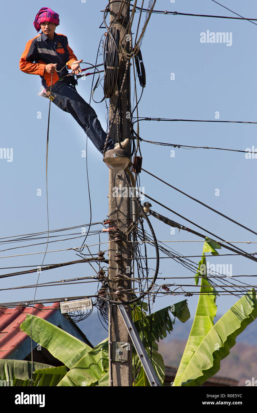 SAI YOK, Thaïlande, le 22 janvier 2016 : Un technicien est la réparation ou vérification de la réseau électrique malpropre dans la ville de Sai Yok, Thaïlande Banque D'Images
