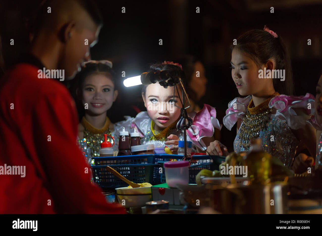 CHIANG MAI, Thaïlande,JANVIER 04,2015 : Un danseur traditionnel thaï est la commande d'une petite fille à la crêpe banane vendeur de rue pendant la nuit du samedi Banque D'Images