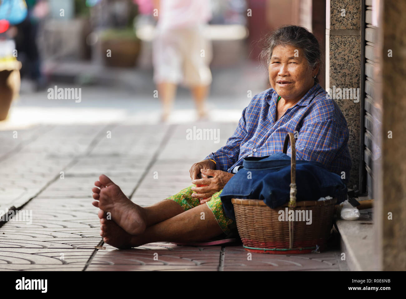 BANGKOK, THAÏLANDE, le 16 décembre 2012 : femme thaïlandaise mendiant assis sur le trottoir dans le quartier de Chinatown à Bangkok, Thaïlande. Banque D'Images