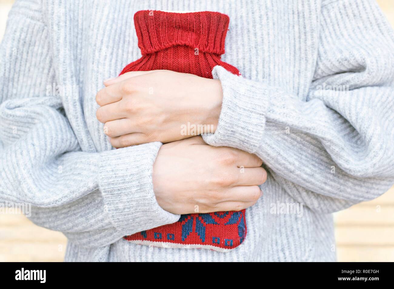 Woman holding hot water bottle, Close up. Banque D'Images