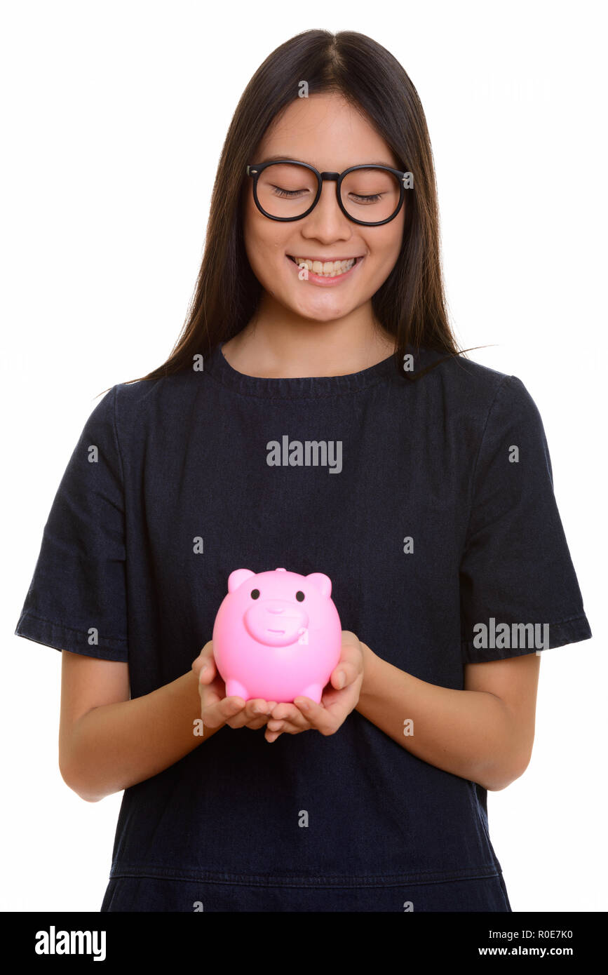 Les jeunes professionnels Asian teenage girl smiling and holding piggy bank Banque D'Images