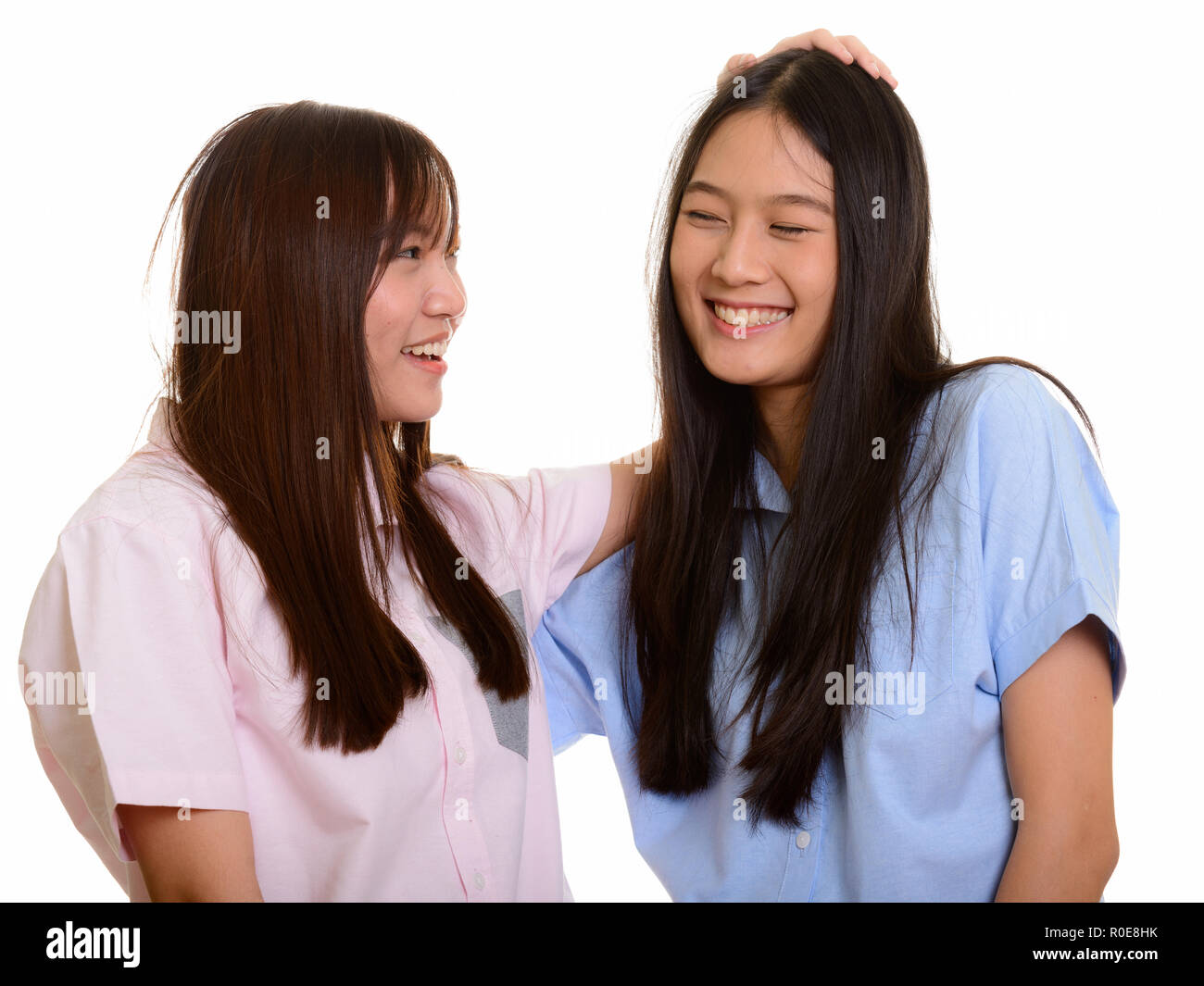 Deux jeunes professionnels Asian teenage girls smiling et tapotant son frie Banque D'Images