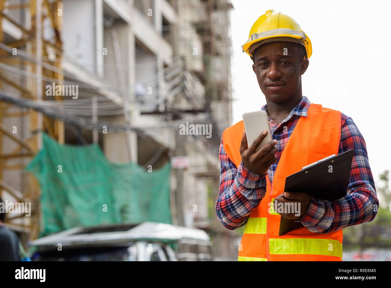 Young black African man construction worker holding un presse-papiers Banque D'Images