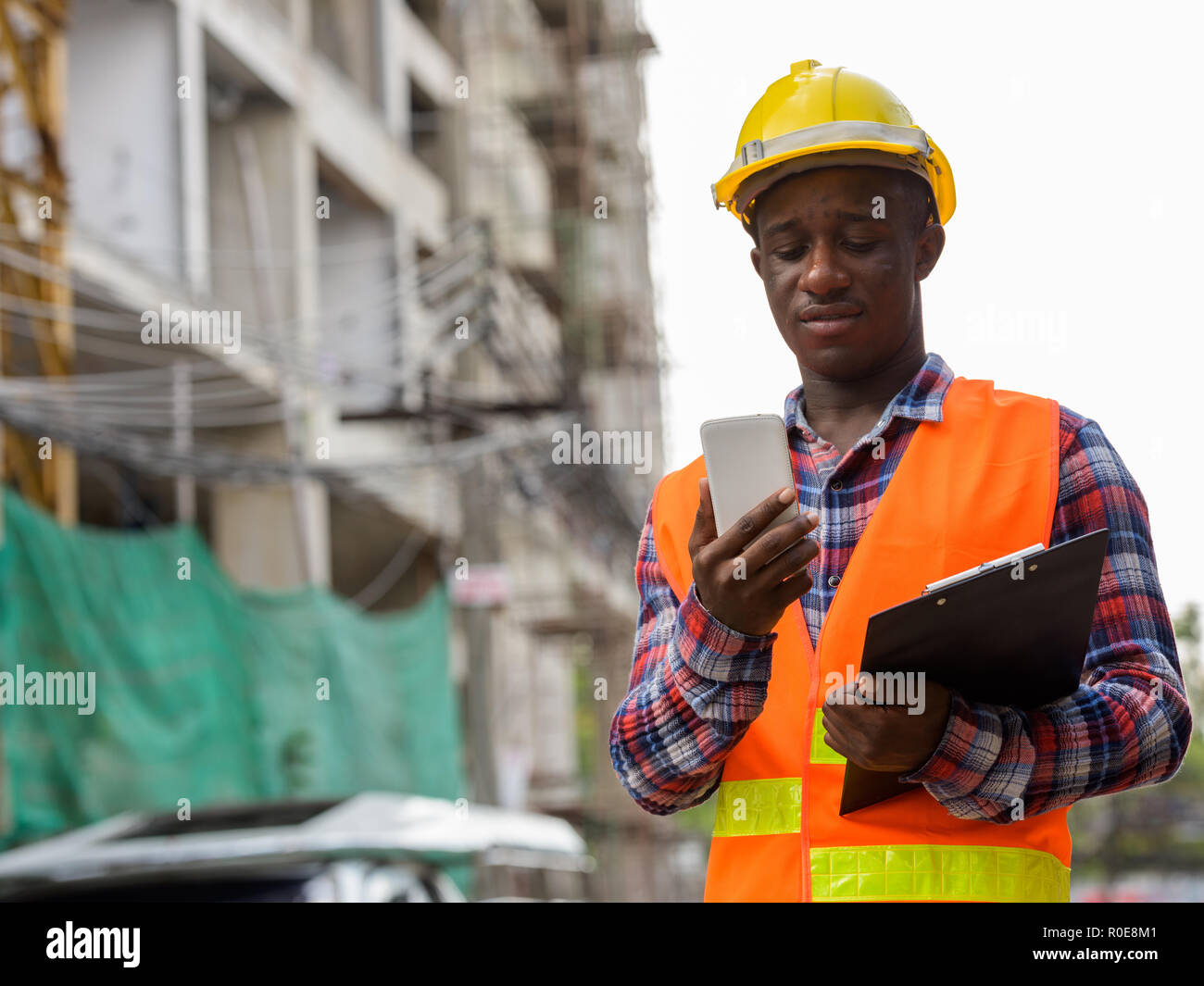 Young black African man construction worker holding clipboard wh Banque D'Images
