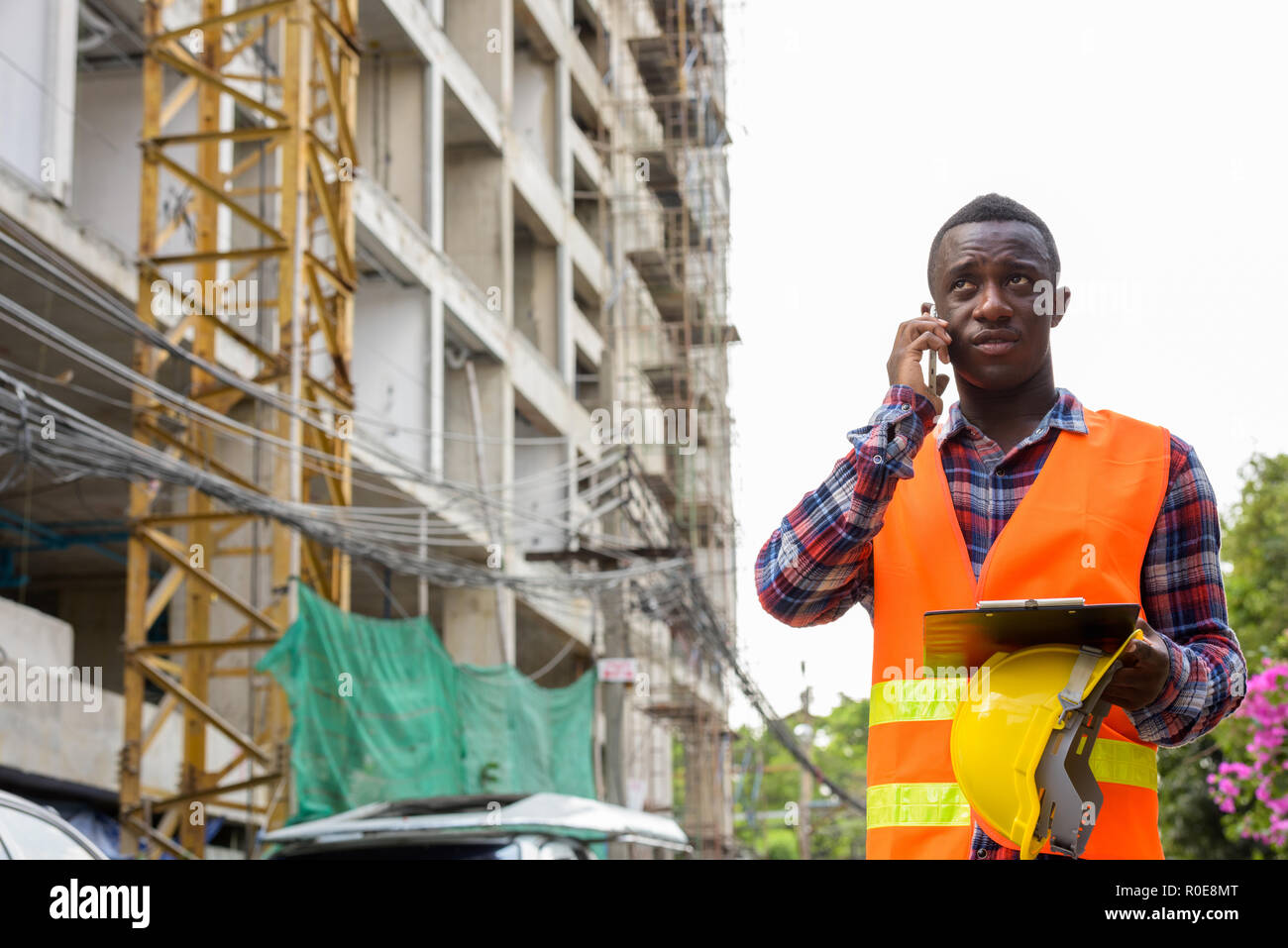 Young black African man construction worker talking o Banque D'Images