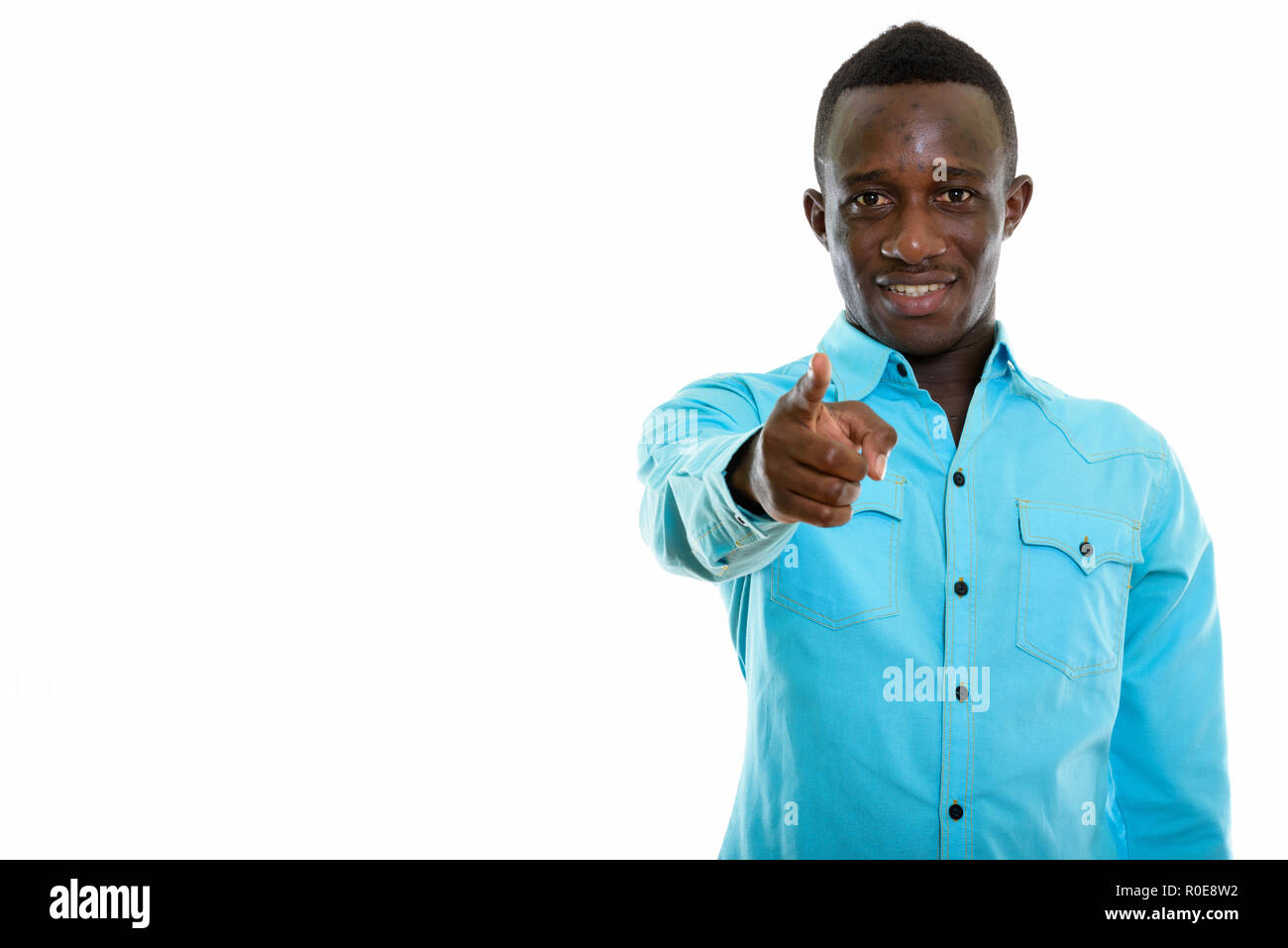 Studio shot of young happy black African man smiling while point Banque D'Images