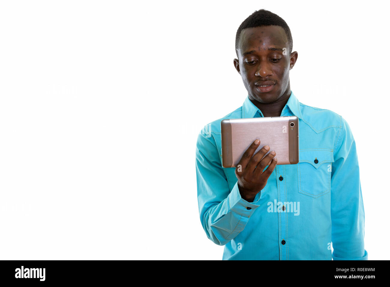 Studio shot of young black African man using digital tablet Banque D'Images