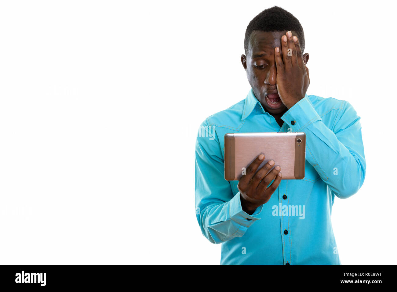 Studio shot of young black African man using digital tablet whil Banque D'Images