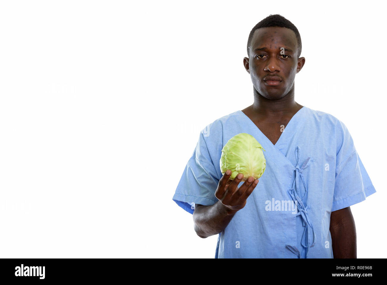 Studio shot of young black African man holding patient cabine vert Banque D'Images