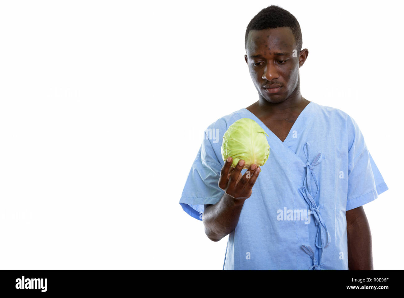 Studio shot of young black African man holding patient et looki Banque D'Images