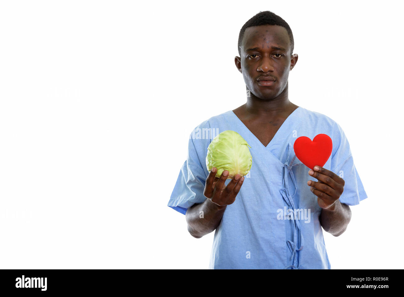 Studio shot of young black African man holding patient cabine vert Banque D'Images