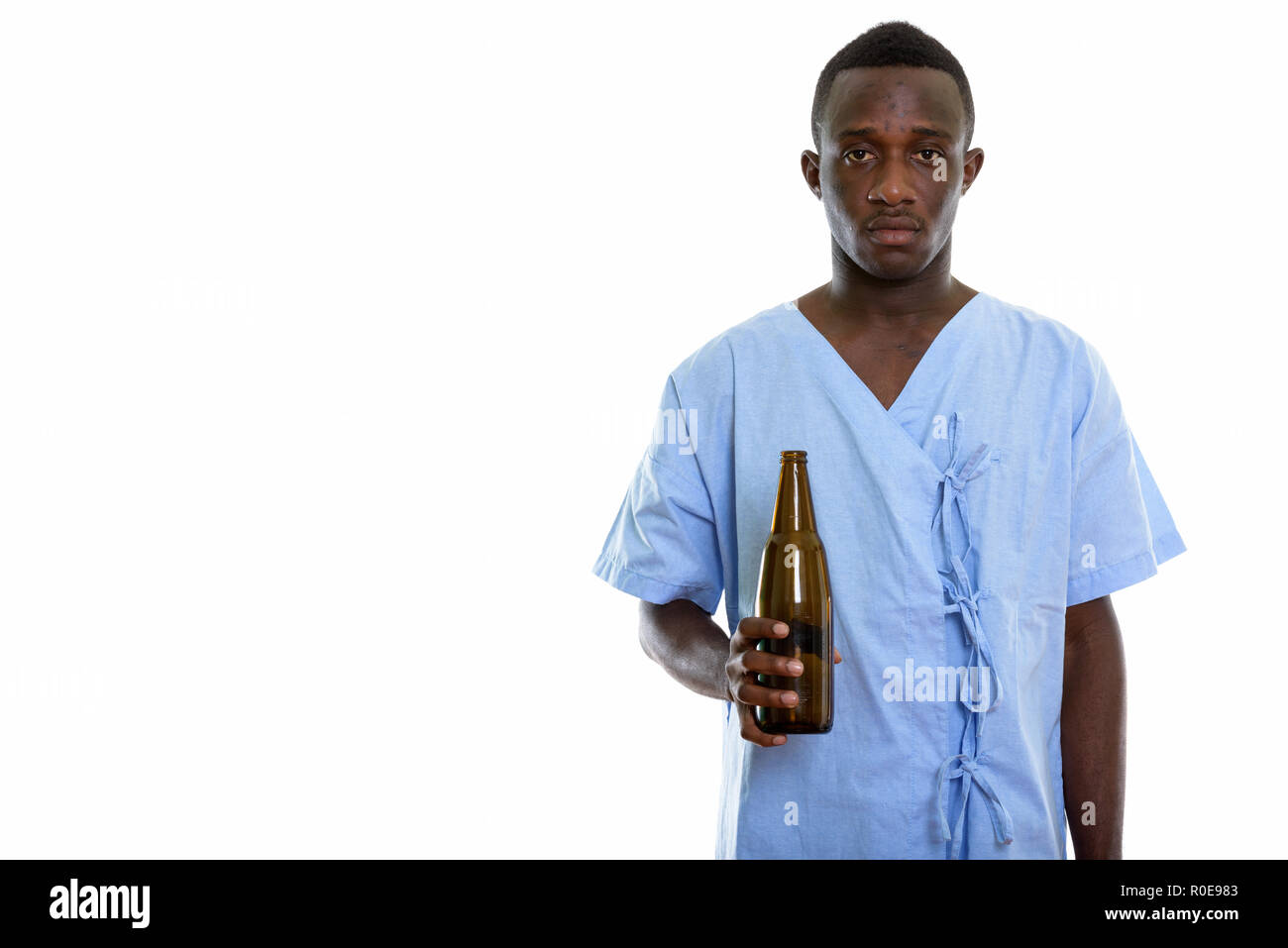 Studio shot of young black African man holding patient bouteille de Banque D'Images