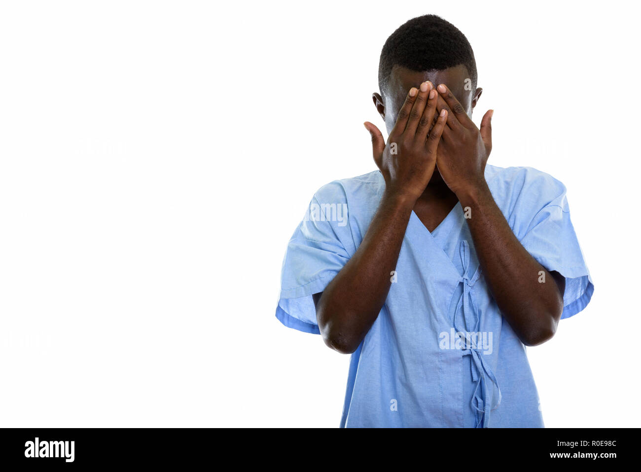 Studio shot of young black African man covering face patient wit Banque D'Images