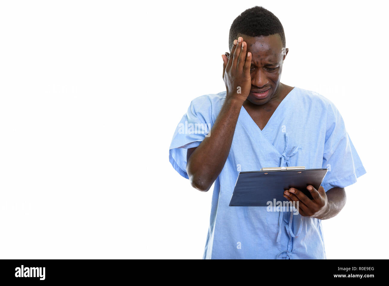Studio shot of young black African man reading patient sur clipbo Banque D'Images