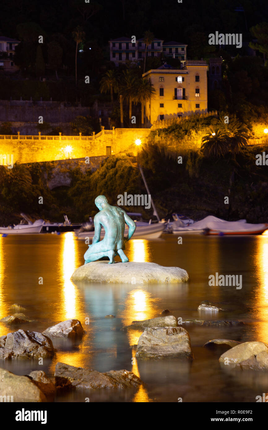 Une vue étonnante de la 'Baie du Silence', Baia del Slienzio, Sestri Levante (Ge), Ligurie, Italie, au crépuscule, avec le pêcheur de bronze sculpture Banque D'Images