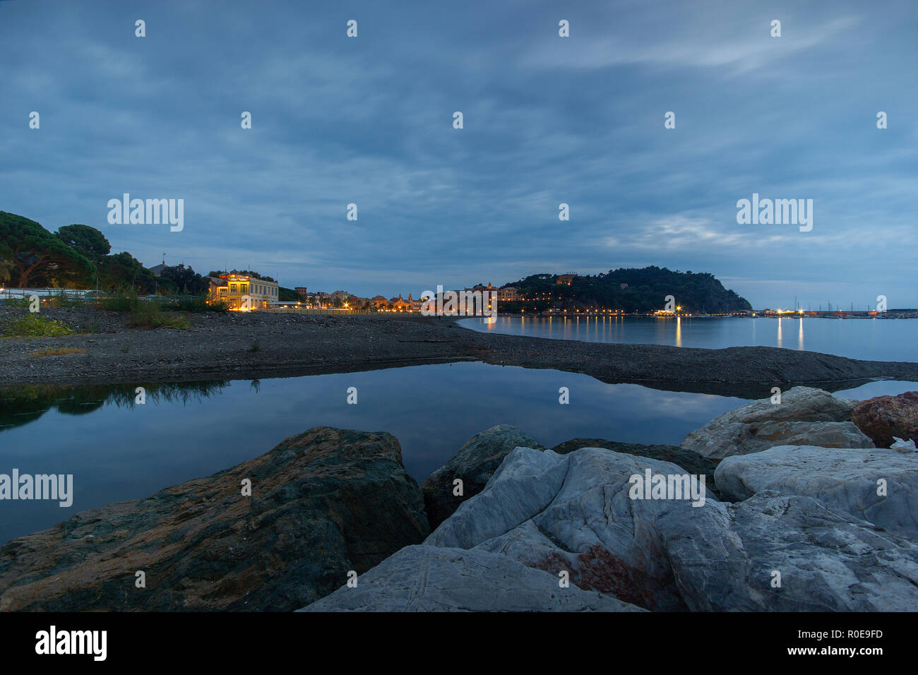Une belle vue grand angle de la station port de Sestri Levante, Ge, Ligurie, Italie, au crépuscule, avec des pierres en premier plan Banque D'Images Une belle vue grand angle de la station port de Sestri Levante, Ge, Ligurie, Italie, au crépuscule, avec des pierres en premier plan Banque D'Images