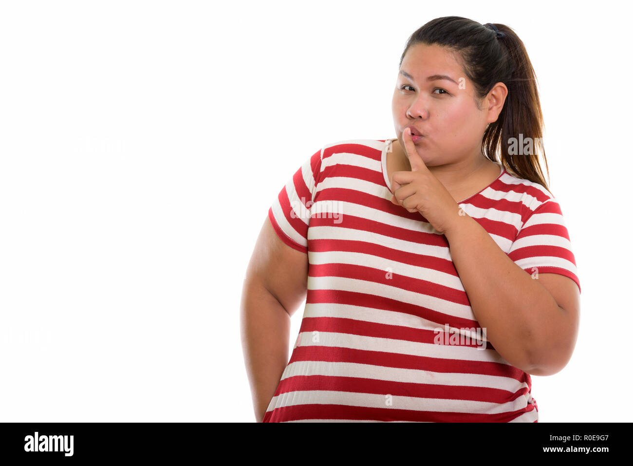 Portrait de jeune femme asiatique en gras avec le doigt sur les lèvres Banque D'Images