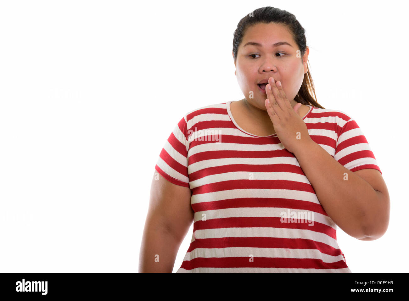 Studio shot of young Asian woman looking fat choqué alors que couvrir Banque D'Images