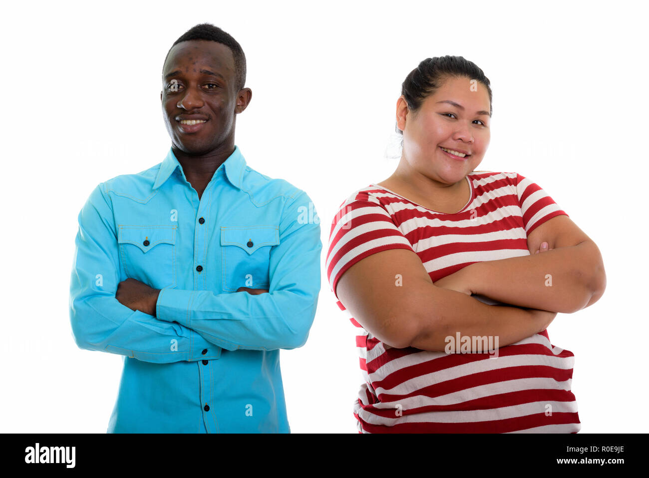 Young happy mixed race woman smiling with arms crossed Banque D'Images