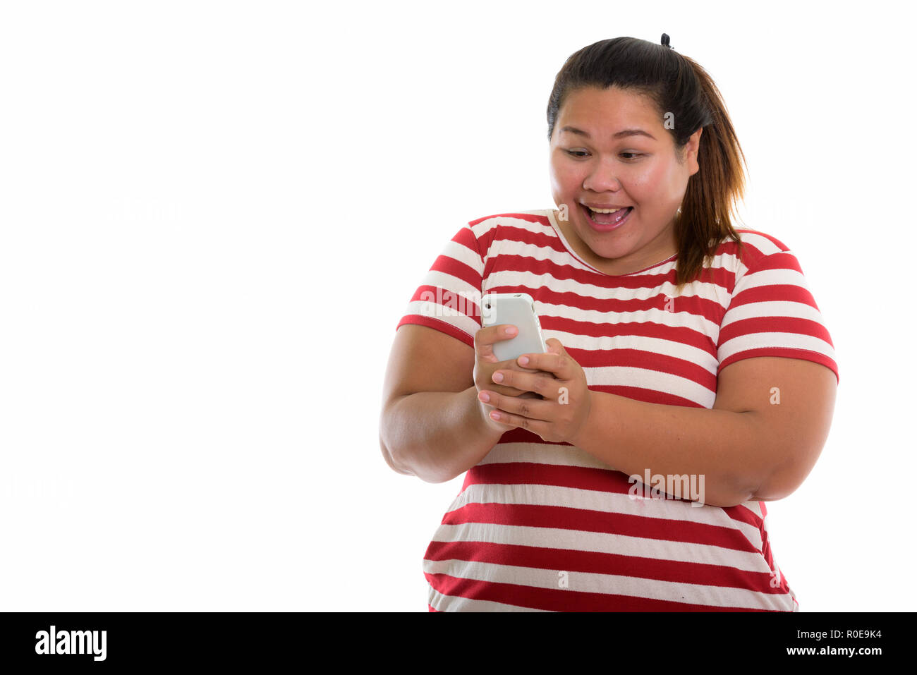 Studio shot of young woman smiling Asian fat heureux lors de l'utilisation de m Banque D'Images